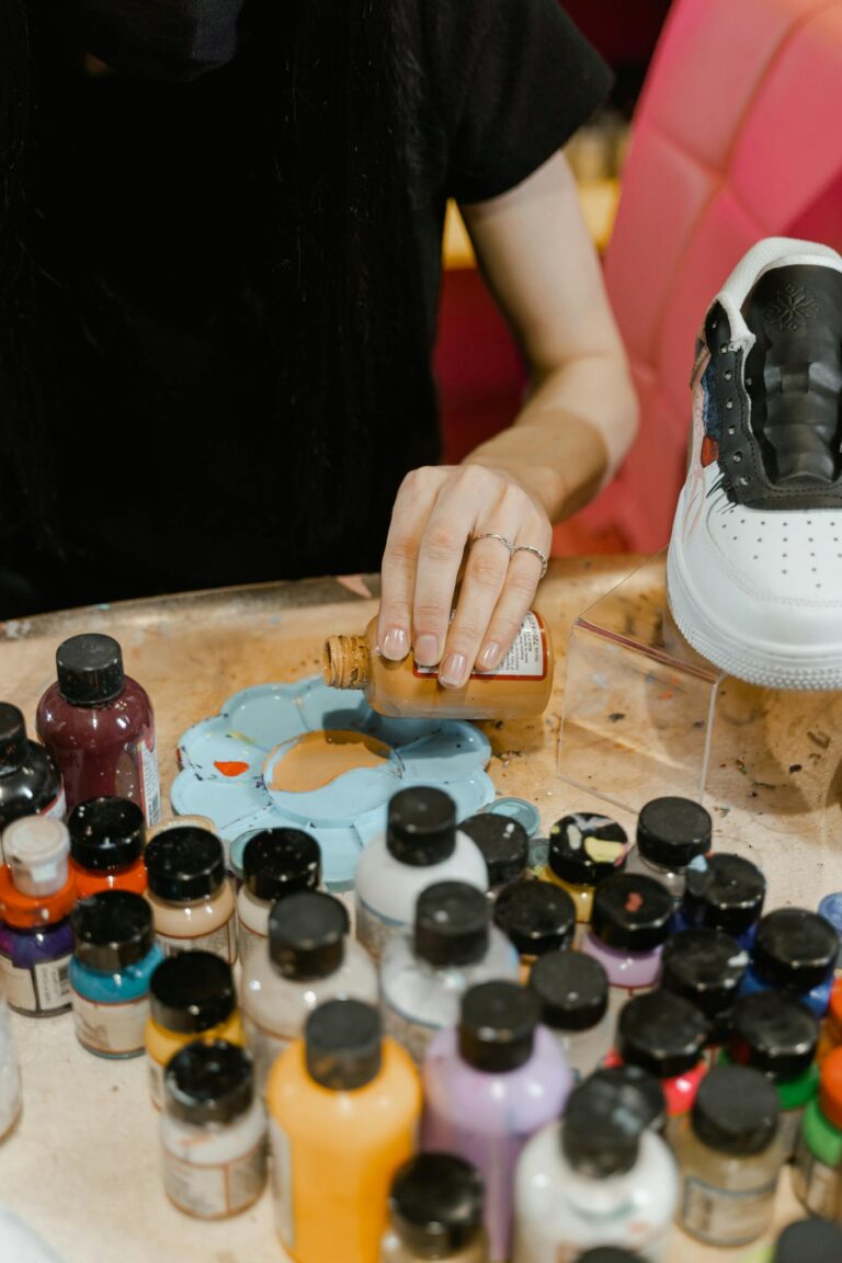 A young artist skillfully blends paints on a palette, preparing to design a unique shoe.